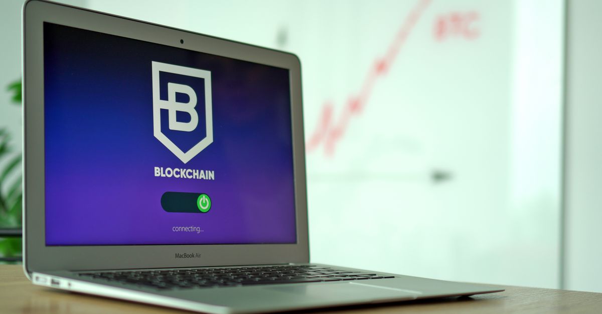 Desk with a laptop and notebook used for managing a crypto wallet
